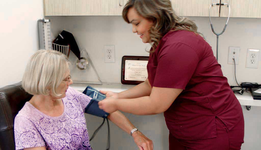 Our Services Our nurse checking a patients blood pressure.